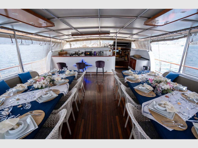 Nevra Queen charter gulet aft deck featuring two dining tables and a bar