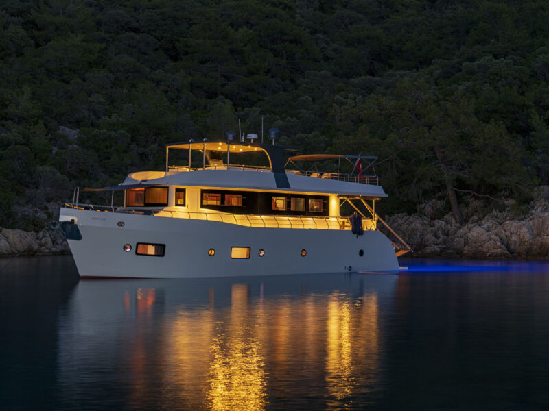 Trawler Oggusto at anchor in the evening with underwater lights on