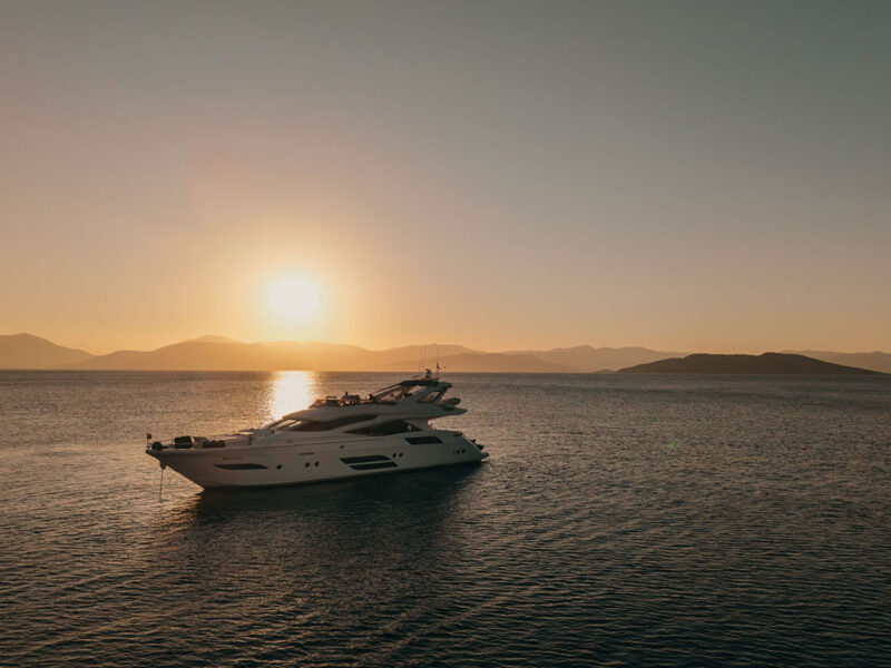 MY Why Not Dominator 780S charter yacht at anchor at sunset