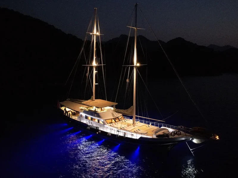 Perla Del Mar gulet exterior aerial drone shot at night with underwater lights on