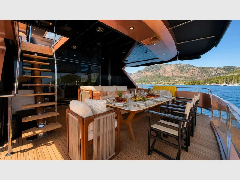 Admiral 115 Poseidon charter motor yacht outdoor aft deck dining table and stairs to upper deck