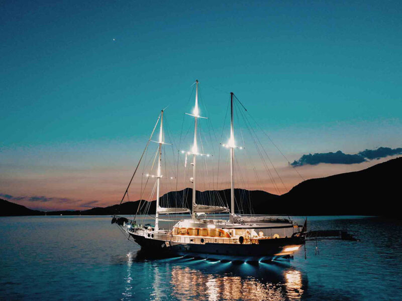 Gulet Bella Mare yatı gece aydınlatması ve su altı led ışıklarıyla deniz üzerindeki görünümü.